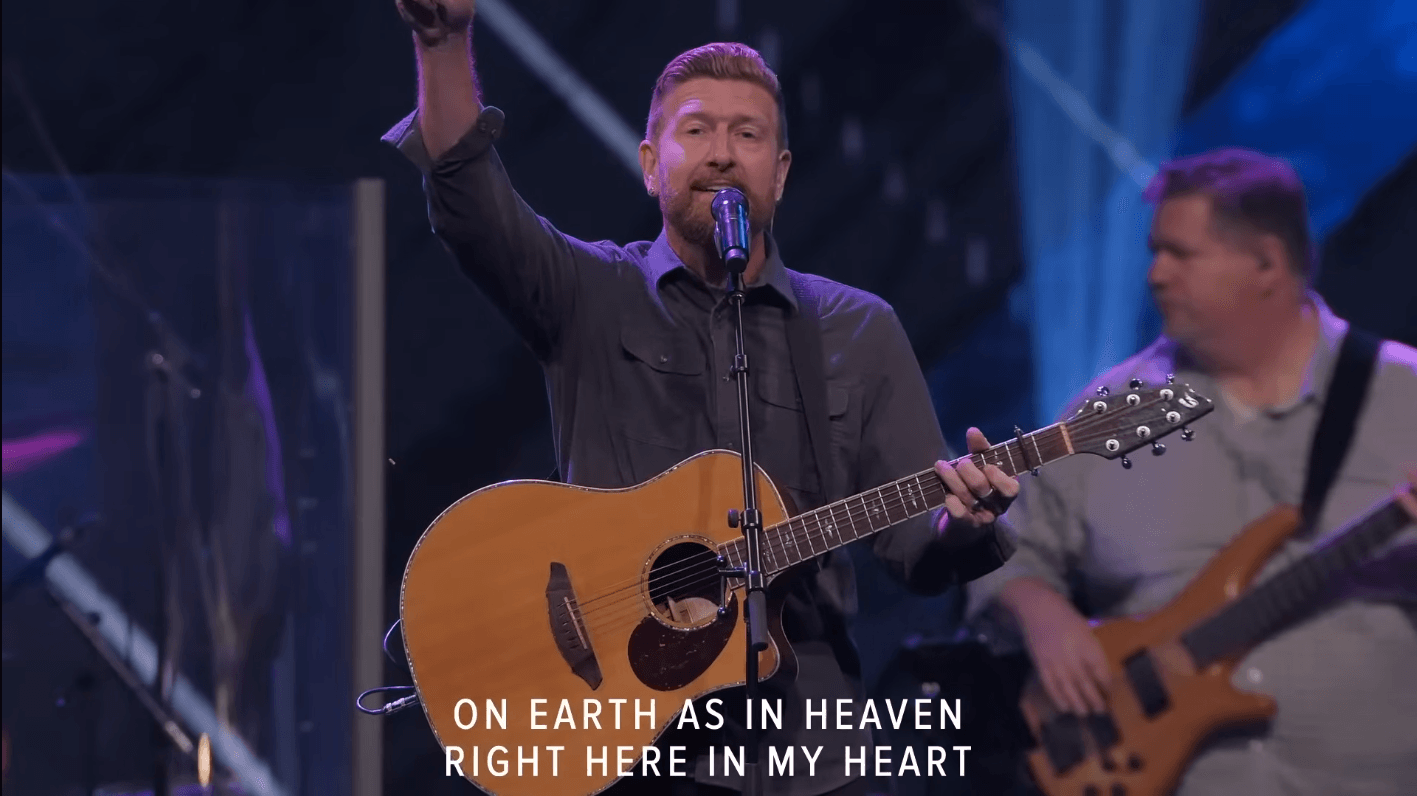Matt Henry leading worship at Grace Church STL — hand raised